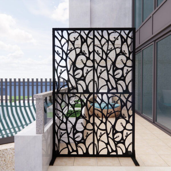 One black metal decorative screen with bird-and-branch cutouts standing on a tiled patio.