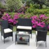Four-piece wicker patio set with beige cushions Black wicker loveseat and two chairs with beige seat cushions around a glass-top patio table