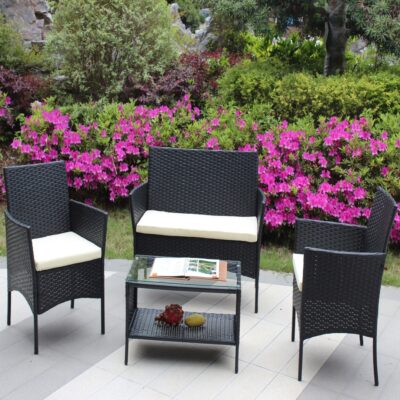 Black wicker loveseat and two chairs with beige seat cushions around a glass-top patio table