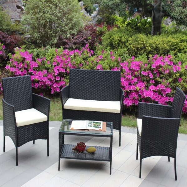 Four-piece wicker patio set with beige cushions Black wicker loveseat and two chairs with beige seat cushions around a glass-top patio table