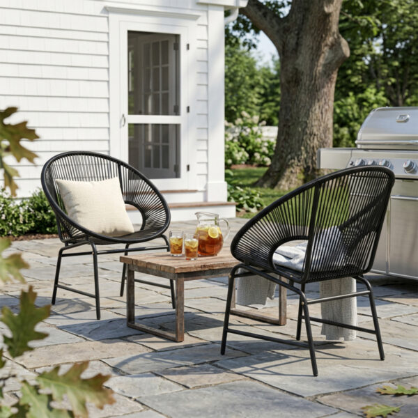 A pair of black PE rattan patio chairs showing their curved seats, open-weave backs and iron frames.