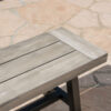 Close-up of the light gray acacia slats and dark metal frame