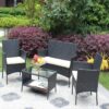 Wicker patio seating set and glass-top table Four-piece black wicker patio seating set with beige cushions and a rectangular glass-top table