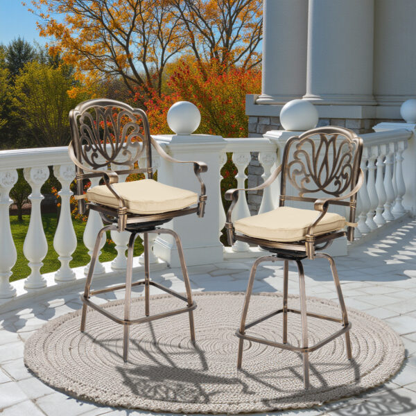 Pair of bronze swivel patio bar stools with beige cushions on an outdoor patio.