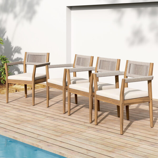 Four acacia and rope dining chairs with cream cushions lined up beside a pool.
