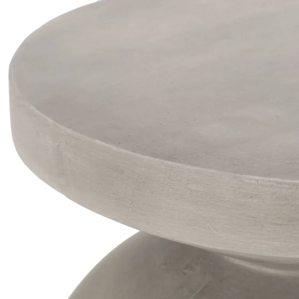 Close view of the side table round top and light gray textured surface.